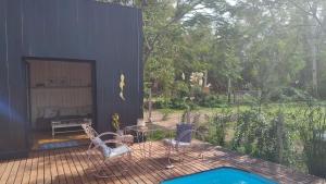 A. de la CruzLa Pausa Casa Rural的庭院设有游泳池、桌子和椅子。