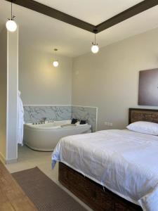 萨维奇منتجع جبل رثباء Rathba Mountain Resort的一间卧室配有一张床和浴缸