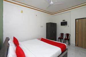 布巴内什瓦尔OYO Aradhya Residency的一间卧室配有一张床和两张红色椅子