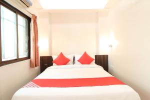 DehuNew Pune Residency的一间卧室配有一张带红色枕头的大床