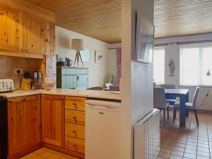 朗德斯通Apartment 235 Roundstone的厨房配有木制橱柜和桌椅