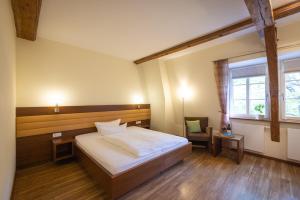 弗赖因斯海姆Altstadthof Freinsheim的卧室配有床、椅子和窗户。