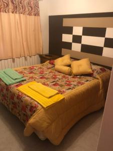 里奥加耶戈斯Vientos del Sur的一张带黄色床单和枕头的床