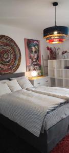 佩特坎内Apartmani Sollei的卧室配有一张大床,墙上挂有绘画作品