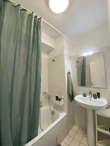 安纳马斯Vaste et lumineux T2的浴室配有淋浴帘和盥洗盆。