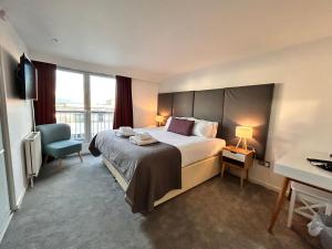 格拉斯哥Tolbooth Apartments by Principal Apartments的酒店客房带一张大床和一把椅子