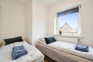 哥本哈根Delicius apartment near the Beach,Metro, Airport的带窗户的客房内的两张床