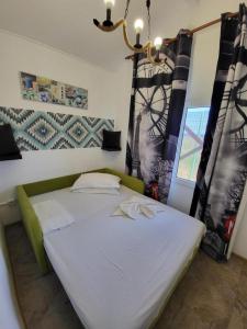 那沃达利Mara si Marea的卧室配有带窗帘和吊灯的白色床。