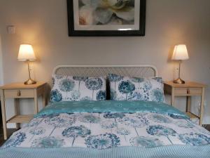 贝尔法斯特Stunning 3 Bedroom townhouse in the heart of city的一张带蓝色和白色床单的床和两盏灯