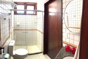 拉巴拉德纳圣米格尔Casa em condomínio, beira mar e piscina Barra de São Miguel - Maceió- AL的一间带卫生间和玻璃淋浴间的浴室