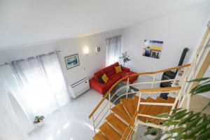 扎达尔Villa Sanda with Private Pool的一间带楼梯和红色沙发的客厅