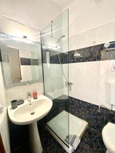 SpílionCostas Inn的一间带水槽和玻璃淋浴的浴室