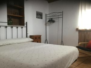 卡萨雷斯拉斯维加斯塔斯迪米阿布维拉乡村民宿的卧室配有白色的床和椅子