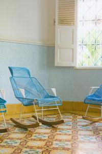 卡塔赫纳Casa Colonial en Manga的一间有地毯的房间,有三把蓝色椅子