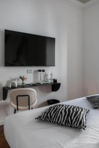 罗马Bhr Cavour 150的卧室配有一张床铺,墙上配有电视