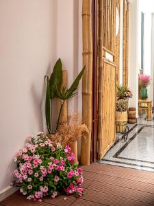 胡志明市Song Anh Indochina Studios Nguyen Thai Binh的坐在门旁边的地板上的一束鲜花