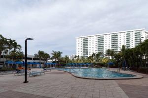 迈阿密海滩Stunning & Spacious Resort-Style Condo Across From Beach!的一座带大型建筑的度假村内的游泳池