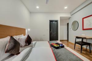 法里达巴德OYO Flagship Hotel Evergreen的配有一张床和一张书桌的酒店客房