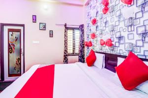 BijnaurOYO Flagship Radhey Krishna Bhawan的一间卧室配有一张带红色枕头的大床