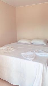 迪亚曼蒂纳Hospedagem em Diamantina的白色的床、白色床单和枕头