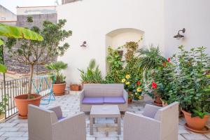 夏卡Casa dell'Aromatario b&b的一个带盆栽和蓝椅的庭院