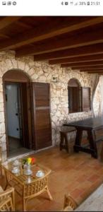 兰佩杜萨VILLA DAIANA的一间设有桌子和石墙的房间