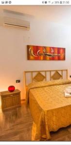 兰佩杜萨VILLA DAIANA的一间卧室配有一张床、一张桌子和一幅画