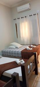 奥林匹亚Angelo Hotel的一间卧室设有两张床和一个带风扇的窗户。