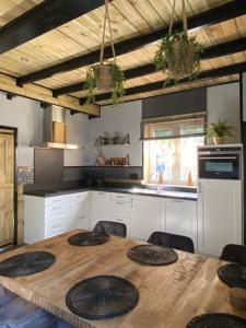 圣安娜兰huisje in zeeland helemaal gerenoveerd的厨房配有带椅子的木桌