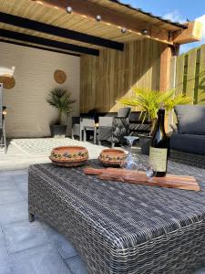 圣安娜兰huisje in zeeland helemaal gerenoveerd的露台上的桌子和一瓶葡萄酒