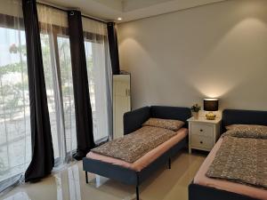 塞拉莱Laguna Apartment HAWANA SALALAH Resort的一间卧室设有两张床和窗户。