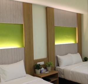 吉隆坡Xpeed Holiday Hotel的绿白色客房内的两张床