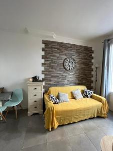 拉西约塔perle rare à la ciotat的一间卧室设有黄色的床和砖墙