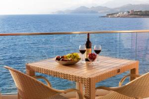 尤塔哈DreamSea Apartment的一张桌子,上面放着一碗水果和两杯葡萄酒
