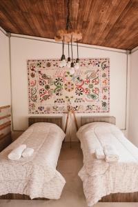 卡梅隆El Rincón. Farm and Lodge的墙上画画的房间里设有两张床