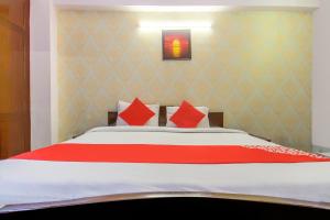 巴特那OYO Flagship 78696 Hotel Kamini的一间卧室配有一张带红色枕头的大床