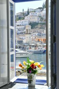 伊兹拉Delfini Hotel的享有海港景致的窗户,设有船只
