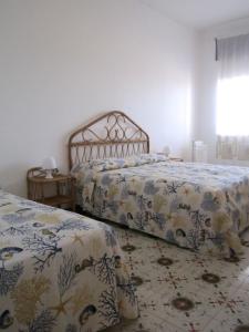拉卡莱Don Vito的一间卧室设有两张床和窗户。