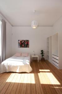 夏洛滕隆Scandi-Hygge Seaside House - only 10mins to Copenhagen的一间铺有木地板的白色卧室,配有一张床