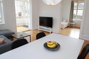 夏洛滕隆Scandi-Hygge Seaside House - only 10mins to Copenhagen的客厅里设有一张桌子,上面放着一碗香蕉