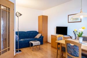 考那亚诺Valtlhof - Apt 1的客厅配有蓝色的沙发和桌子