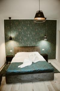 锡比乌ARINI WHITE HOUSE的一间卧室配有一张白色的床和绿色的墙壁
