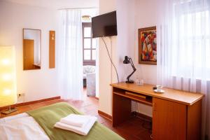 菲尔特Hotel Sofra的一间卧室配有一张床、一张书桌和一台电视