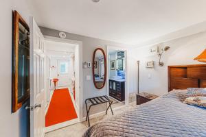 普罗温斯敦Captivating Cottage的一间卧室配有一张床和镜子