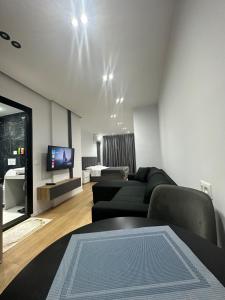 地拉那CozyStayApartments的带沙发和电视的客厅