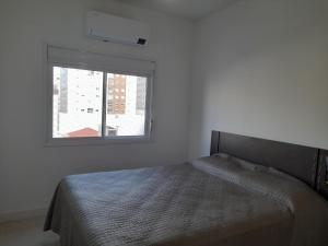 卡庞达卡诺阿Confortável apartamento na praia的白色客房的一张床位,设有窗户