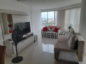 卡庞达卡诺阿Confortável apartamento na praia的带沙发和电视的白色客厅