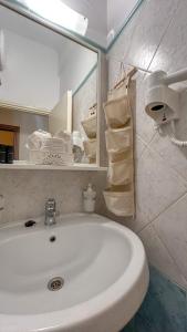 埃尔莫波利斯Central 9 Rooms的浴室配有盥洗盆、镜子和毛巾