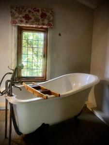 哈特比斯普特Mill Lane Farmhouse的带窗户的浴室内的白色浴缸