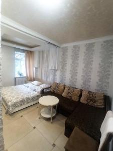 捷尔诺波尔Готель Жасмин的一间卧室配有一张床、一张沙发和一张桌子